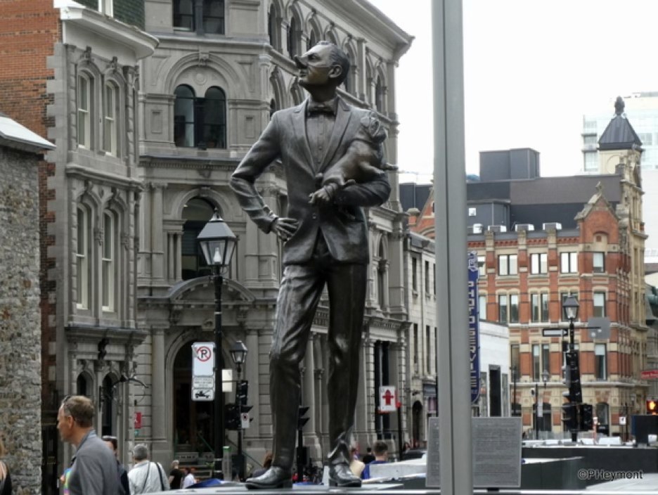 Bronze statue of a snooty man holding a pug in Old Montreal
